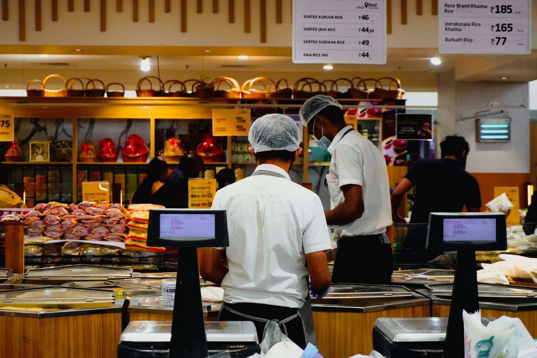 A supermarket floor manager working with a retail team in a stocked aisle